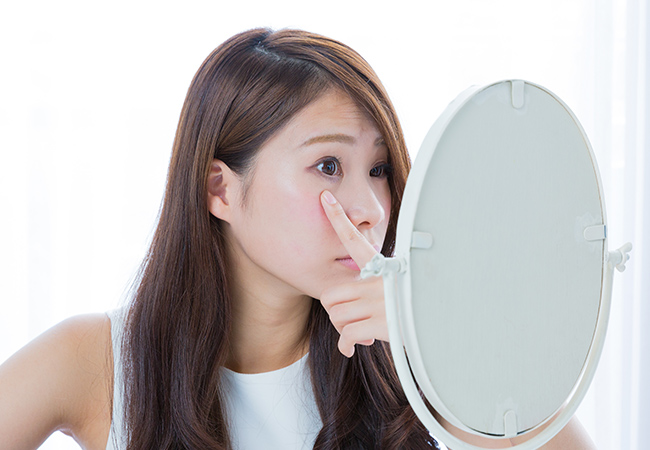 目を鏡で確認する女性